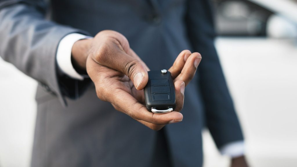 Car rental concept. Man holding car key in hand